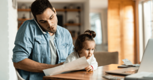 Man looking at paper while girl stares at computer